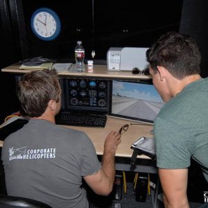 Instructor and student review flight performance on computers.